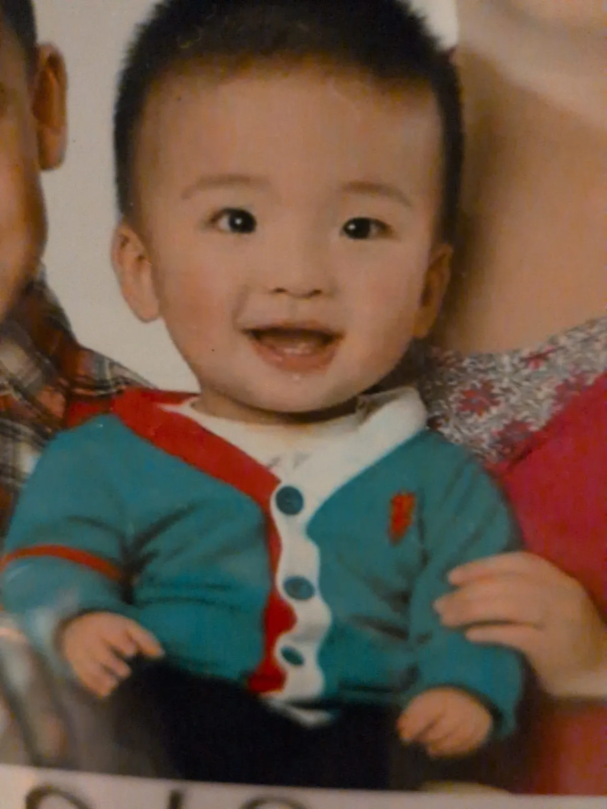 Ian as a toddler in a blue cardigan