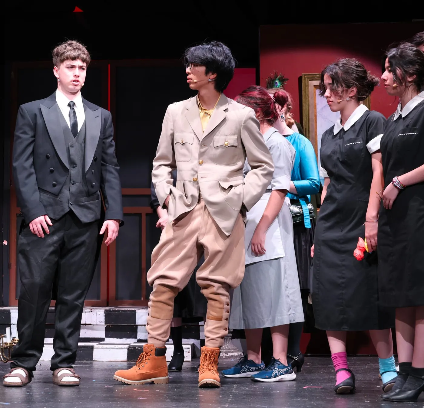 Ian mid-scene with the ensemble on a chequered stage floor